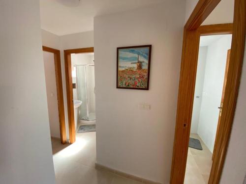 ein Flur mit einem Gemälde an einer weißen Wand in der Unterkunft Seaside Dreams in Santa Pola