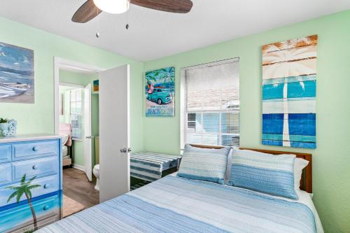 a bedroom with a bed and a window at Canary Beach Cottage in Clearwater Beach