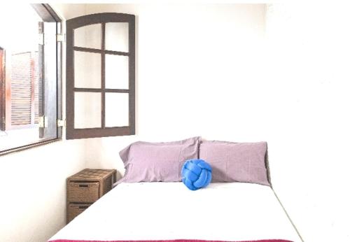 ein Schlafzimmer mit einem Bett mit blauer Blume darauf in der Unterkunft SUITES CONFORTÁVEIS CASAL OU QUATRO PESSOAS in São Sebastião