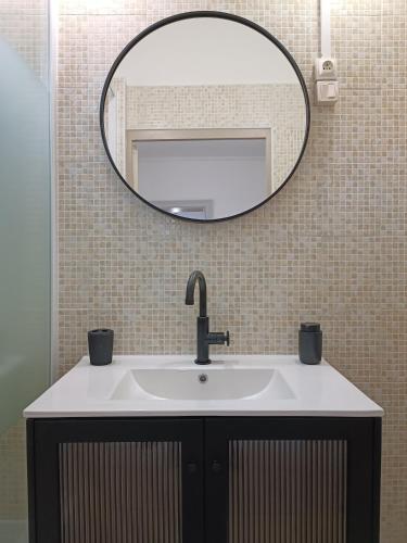 La salle de bains est pourvue d'un lavabo et d'un grand miroir. dans l'établissement Cœur de Loire, à Blois