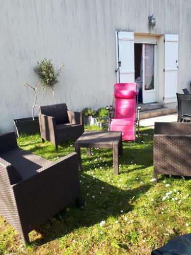 a group of chairs and tables in a yard at Chambres chez l habitant in Saint-Sauveur