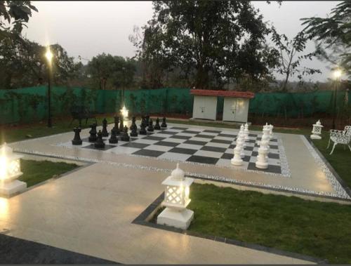 a large chess board on a lawn with a giant chessboard at Sukoon Holiday Home in Chinchavli