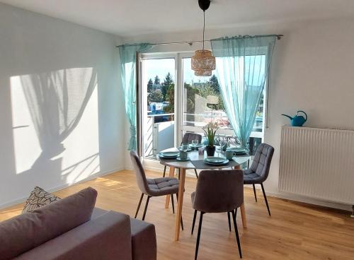 sala de estar con mesa, sillas y sofá en Moderne Wohnung mit Vollausstattung in ruhiger Lage, W-LAN, en Großröhrsdorf