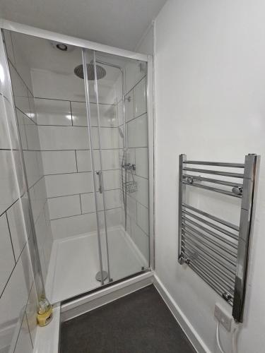 Luxury one bedroom maisonette with extra connected bedroom in Stevenage centre في ستيفنيج: حمام مع دش مع باب زجاجي