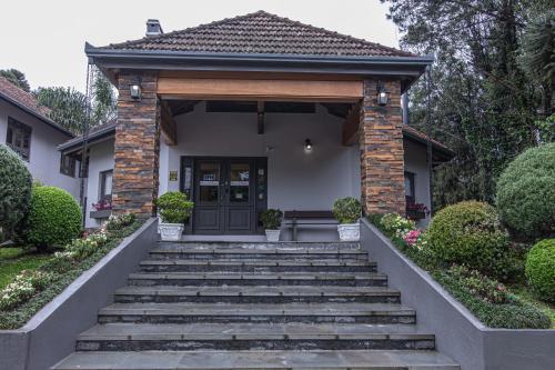a house with stairs leading up to a door at Pousada Villa Verde in Canela