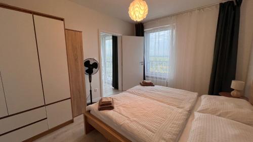 1 dormitorio con cama y ventana grande en 2 room Apartment with terrace, new building, 8BJ en Bratislava