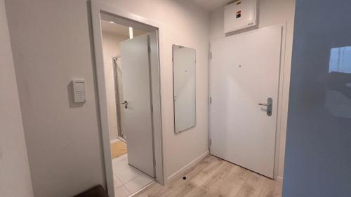 a hallway with two doors and a mirror at 2 room Apartment with terrace, new building, 8BJ in Bratislava