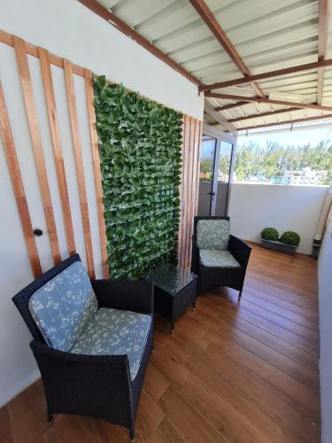 a room with two chairs and a green wall at West Beach in Flic-en-Flac