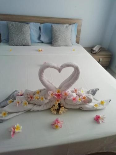 a bed with two hearts made out of flowers at West Beach in Flic-en-Flac