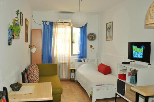 ein kleines Wohnzimmer mit einem Bett und einem Sofa in der Unterkunft Studio5, sa parkingom, centar Obrenovca in Obrenovac