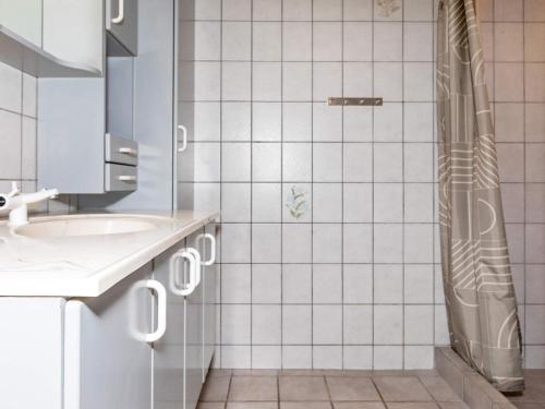 y baño de azulejos blancos con ducha y lavamanos. en Holiday home Thisted LVII en Thisted