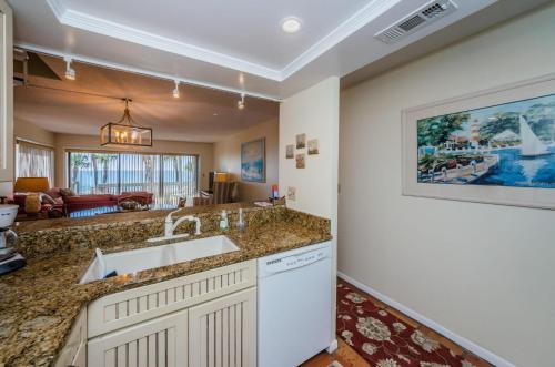 a kitchen with a sink and a living room at Beachfront Aldea 6 in Clearwater Beach