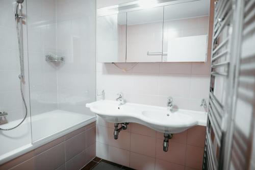 een witte badkamer met een wastafel en een douche bij Vienna Shopping Center 8 Appartment in Wenen