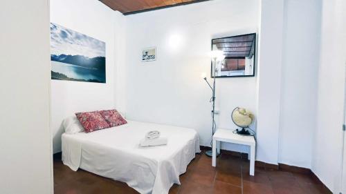 ein weißes Zimmer mit einem Bett und einem Tisch in der Unterkunft Apartamento con Terraza en la Playa con Piscina in La Cala del Moral