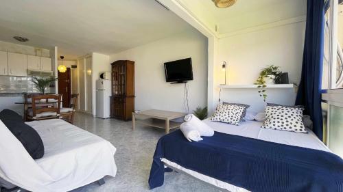 - une chambre avec 2 lits et une télévision dans l'établissement Magnífico estudio con Piscina en la Playa, à Cala del Moral