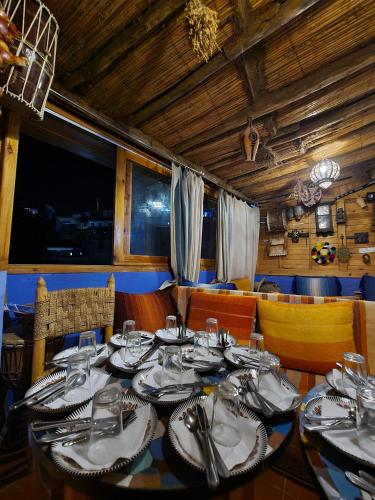 a dining room with a table with plates and silverware at Casa Blue Star in Chefchaouene