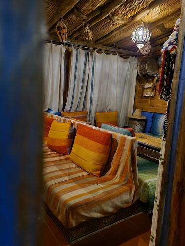 a bed with colorful pillows in a room at Casa Blue Star in Chefchaouene