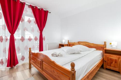 a bedroom with a bed with red curtains at Pensiunea Cascada in Nemesi