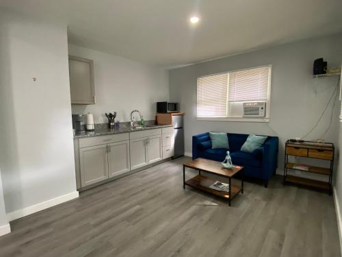 a living room with a blue couch and a kitchen at The Oasis in Sanford