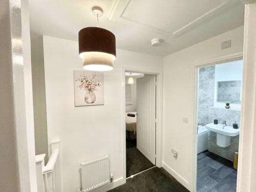 pasillo con baño con lavabo y espejo en Folkestone 3 Bedroom with private parking and EV car outlet near M20 easy access to Eurotunnel, Dover & Dungeoness, en Sandgate