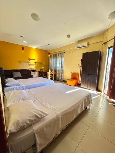 a bedroom with two beds and a yellow wall at Hotel Centro Villarrica in Villarrica
