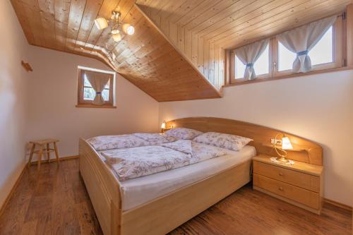 a bedroom with a bed and a wooden ceiling at Schusterhof - Urlaub auf dem Bauernhof in Novale