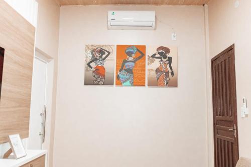 a room with three paintings on the wall at Urban center apartamentos in Salto del Guairá