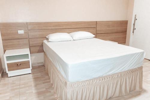 a bedroom with a large bed with a wooden headboard at Urban center apartamentos in Salto del Guairá