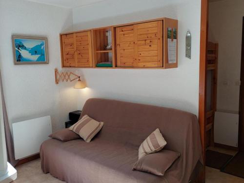 - une chambre avec un lit et des placards en bois dans l'établissement Deux pièces calme proche centre Chamonix, garage, casier à ski, 4 pers. - FR-1-517-61, à Chamonix-Mont-Blanc