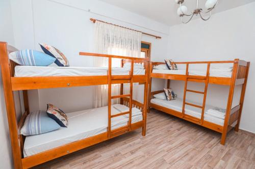 una camera con tre letti a castello in una casa di NANA a Vlorë