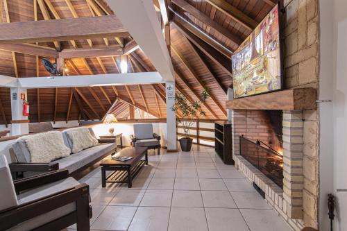 a living room with a couch and a fireplace at Pousada Villa Verde in Canela