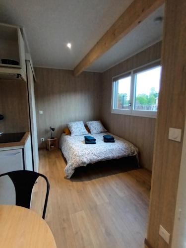 a bedroom with a bed and a table and a window at La Cabane de Camille 