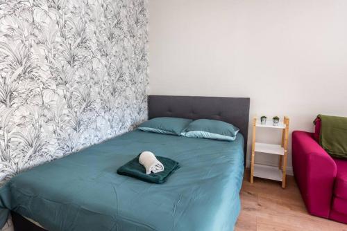 Una cama con sombrero en un dormitorio en Le Saint Just B avec salle de sport, en Rouen