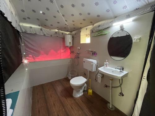 a bathroom with a toilet and a sink in a tent at Camp Serene in Bhīm Tāl