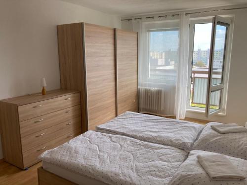 una camera con letto, cassettiera e finestra di 2 rooms apartment with balcony a Zvolen