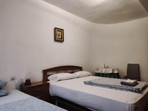 a bedroom with two beds and a table with a chair at Habitacion in Alicante