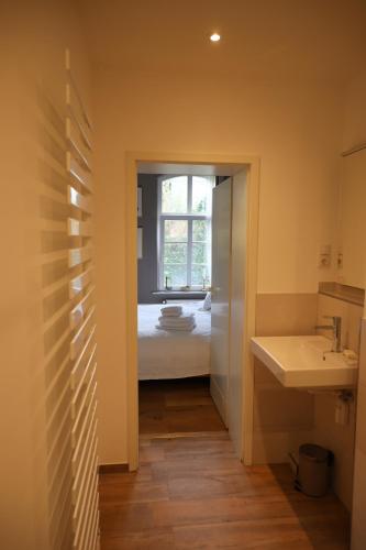 baño con lavabo y cama con ventana en Altes Schulhaus in der Lüneburger Heide, en Lachendorf