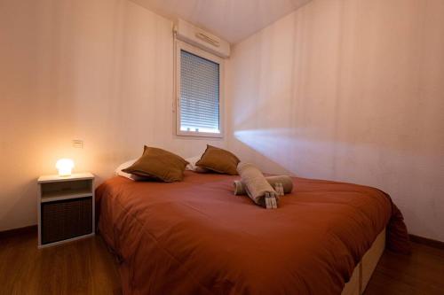 1 dormitorio con 1 cama grande de color naranja y ventana en Cocon cosy 3 pers, Colomiers - So Cozy, en Colomiers