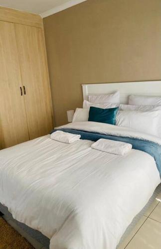 a large white bed with two pillows on it at Central Gabs Oasis: 2BR-Retreat in Gaborone