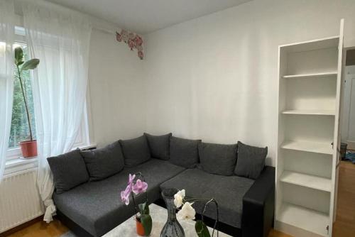 a living room with a gray couch and a shelf at Private Apartment in Hannover