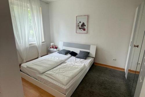 a bedroom with a bed with white sheets and blue pillows at Private Apartment in Hannover