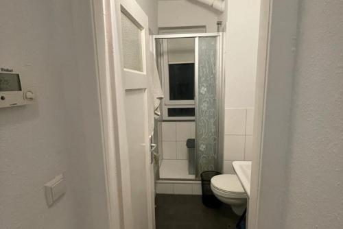 a white bathroom with a toilet and a window at Private Apartment in Hannover