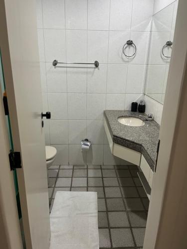 a bathroom with a sink and a toilet at Loft com vista da praia da Costa 612 in Vila Velha
