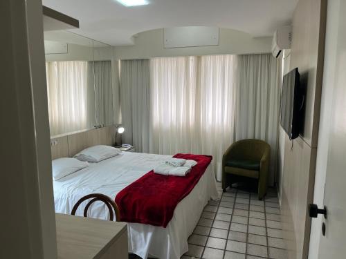 a hotel room with a bed and a chair at Loft com vista da praia da Costa 612 in Vila Velha