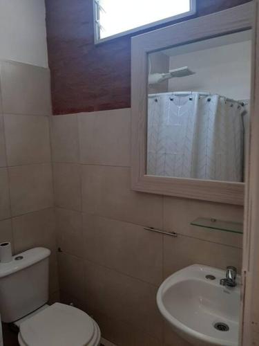a bathroom with a white toilet and a sink at Temporario Necochea 2 corrientes in Corrientes