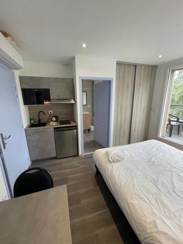 une chambre d'hôtel avec un lit et une cuisine dans l'établissement LE SALVADOR - Appart'Hôtel de 18m2 à 44m2, à La Talaudière