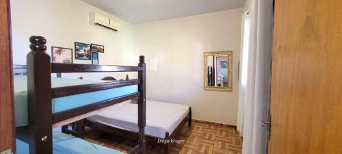 een slaapkamer met 2 stapelbedden en een spiegel bij Casa perto das Cataratas Seu lar para quatro in Foz do Iguaçu