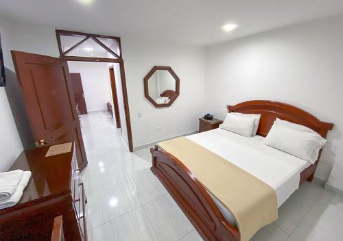 een slaapkamer met een groot bed en een spiegel bij Hotel Exelsior in Cúcuta