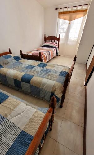 Dos camas una al lado de la otra en una habitación. en Los Trineos, en Ushuaia
