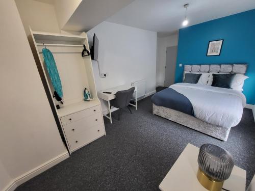 a bedroom with a bed and a blue wall at Nottingham Forest Rd, Short Stays in Nottingham